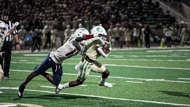 Week 5: Chaminade-Madonna defender Zaquan Patterson goes airborne to try to get ahold of Buford running back Victor Venn. (Photo by Josh Major)